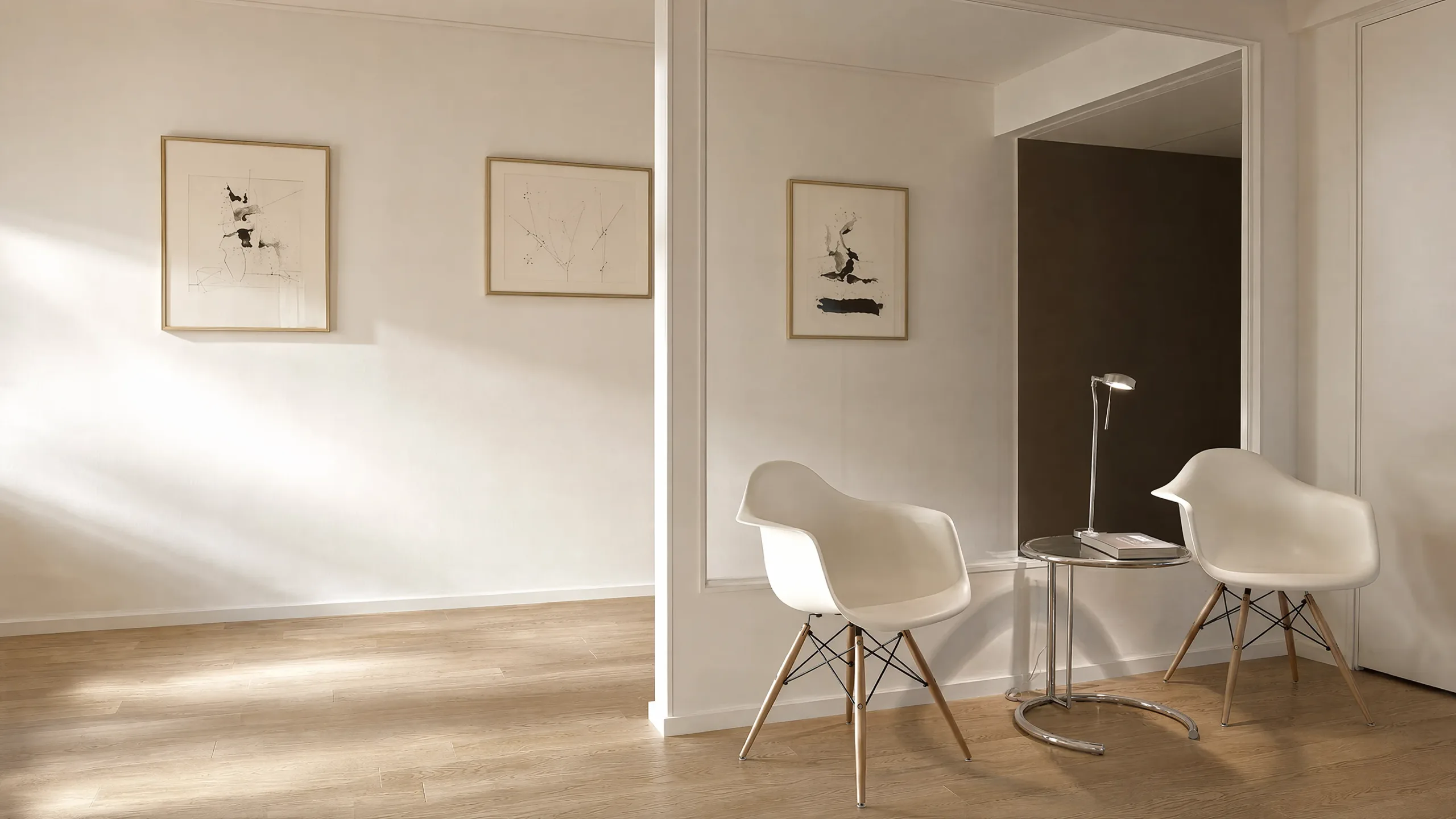 Wartebereich der Haar Concept Praxis in München mit zwei Schalensesseln, Beistelltisch und gerahmten Zeichnungen an heller Wand